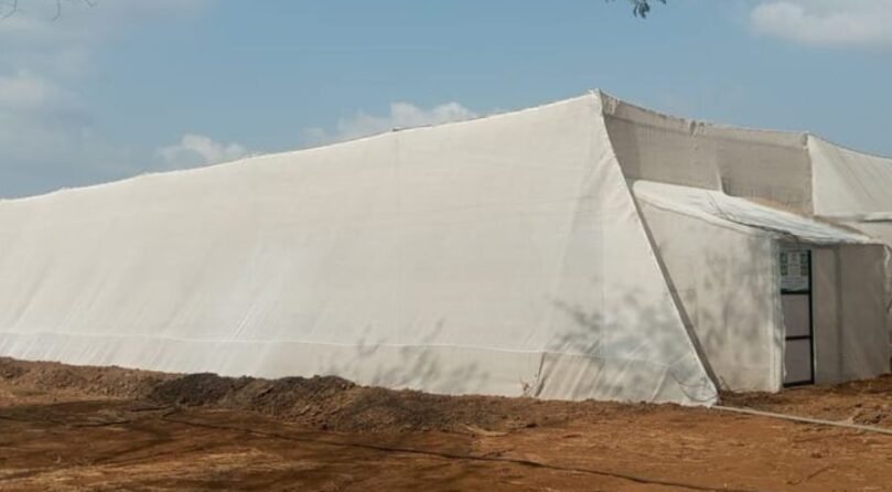 Wire Rope Shade Net House Wire rope supported shade net house structure protecting crops in an agricultural field in India by JH Agriinfra